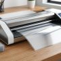 Office laminator sealing a document inside a clear pouch.